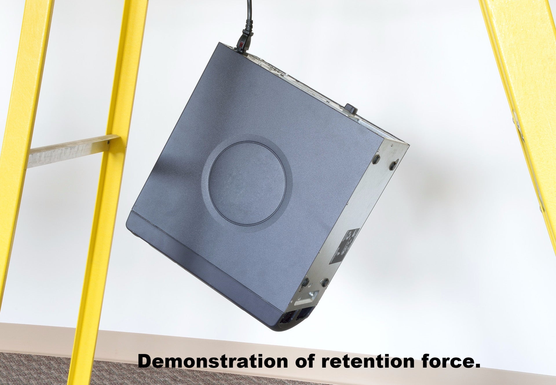 Demonstration of retention force - Desktop computer hanging from cord